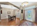 Dining room with hardwood floors, elegant table, and large window with plantation shutters at 1031 Kings Hwy, Kissimmee, FL 34744