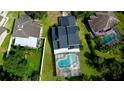 Aerial view of a home with a screened pool and lush green surroundings at 10747 Satinwood Cir, Orlando, FL 32825
