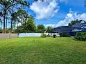 Spacious backyard featuring a well-maintained lawn and privacy fence at 10747 Satinwood Cir, Orlando, FL 32825