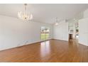 Bright living room featuring laminate floors, large windows, and elegant chandeliers, perfect for gatherings at 10828 Cherry Oak Cir, Orlando, FL 32817