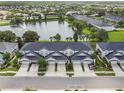 Stunning aerial view of townhomes next to a serene lake with fountain, lush landscaping and neighborhood at 1275 Shallcross Ave, Orlando, FL 32828