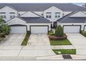 Townhome exterior featuring attached garages, well-manicured landscaping, and a modern design at 1275 Shallcross Ave, Orlando, FL 32828