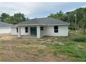 Rear exterior with sliding glass doors and a covered patio at 14489 Se 38Th Ter, Summerfield, FL 34491