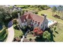 Aerial view of estate featuring a clay tile roof, stone turret, swimming pool, and professionally landscaped grounds at 1477 Shadwell Cir, Lake Mary, FL 32746