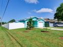 The beautifully landscaped front yard features a healthy green lawn, young trees, and a white privacy fence at 1618 Oregon Ave, St Cloud, FL 34769