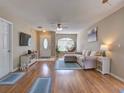 Inviting living room with wood floors, stylish furniture, and a decorative hanging chair by the window at 1618 Oregon Ave, St Cloud, FL 34769