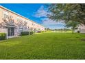 Serene backyard view of the townhome, showcasing a lush lawn with a tranquil pond at 16449 Cedar Crest Dr, Orlando, FL 32828