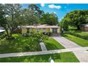 Charming single-story home boasts lush landscaping, a brick driveway, and inviting curb appeal at 1649 W Waycross Cir, Deltona, FL 32725