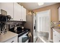 Bright kitchen features white cabinets, stainless steel appliances, and modern backsplash at 1649 W Waycross Cir, Deltona, FL 32725