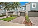 Townhouse exterior displaying gray stucco and stone accents, complemented by a brick driveway at 1852 Garden Sage Dr, Oviedo, FL 32765