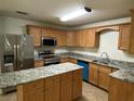 Well-equipped kitchen with stainless steel appliances, granite countertops, and wooden cabinetry at 211 Valencia Rd, Debary, FL 32713