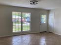 Bright living room featuring neutral walls, tile floors, a large window and stylish light fixture at 211 Valencia Rd, Debary, FL 32713