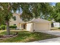 Inviting home with a two-car garage and a charming, well-manicured front yard and lawn at 2255 Tealwood Cir, Tavares, FL 32778