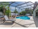 Inviting screened-in pool area with clear blue water, lounge chair, and surrounding patio space at 2406 Blossomwood Dr, Oviedo, FL 32765