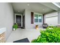 Inviting front porch featuring a seating area and lush landscaping, perfect for relaxing at 251 Brave Rd, Davenport, FL 33837