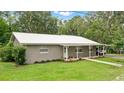 Inviting single-story home with a metal roof, well-manicured lawn, and charming landscaping at 255 Belinda Dr, Deland, FL 32720