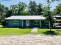 Quaint single-story home boasting a metal roof, well-maintained lawn, and a freshly painted exterior at 255 Belinda Dr, Deland, FL 32720