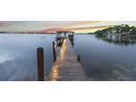 Picturesque lake view featuring a wooden dock with a gazebo at sunset at 2652 Lake Howell Ln, Winter Park, FL 32792