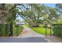 Long brick paved driveway framed by mature trees leads to the property at 2652 Lake Howell Ln, Winter Park, FL 32792
