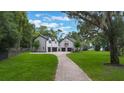 Charming home featuring a neatly paved driveway leading to attached garages and a lush lawn at 2652 Lake Howell Ln, Winter Park, FL 32792