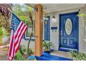 Close-up of front porch featuring blue door, American flag, and decorative plants at 2910 Hargill Dr, Orlando, FL 32806
