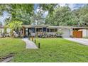 Inviting single-story home with a lush green lawn, mature trees, and a walkway leading to the front door at 2910 Hargill Dr, Orlando, FL 32806