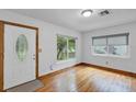 Bright living room with hardwood floors, a front door, and a large window with a view of the trees at 2910 Hargill Dr, Orlando, FL 32806