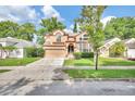Charming two-story home with manicured lawn, trees, and a two-car garage at 2971 Cayman Way, Orlando, FL 32812