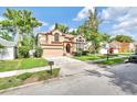 Front view of two-story home featuring well-kept landscaping and a driveway at 2971 Cayman Way, Orlando, FL 32812