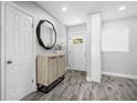 Stylish entryway featuring an accent mirror, modern console table, and light gray wood grain flooring at 3251 Wickersham Ct, Orlando, FL 32806