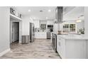 Bright kitchen features stainless steel appliances, white cabinetry, and wood-look flooring at 3251 Wickersham Ct, Orlando, FL 32806