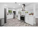 Modern kitchen with stainless steel appliances, white cabinets, and a stylish range hood at 3251 Wickersham Ct, Orlando, FL 32806