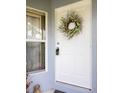 Close up of front door, wreath and lockbox with window beside the door at 342 Lakebreeze Cir, Lake Mary, FL 32746