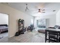 Bright living room featuring wood-look tile flooring, ceiling fan, sliding glass doors to balcony, and neutral paint at 4833 Cypress Woods Dr # 4205, Orlando, FL 32811