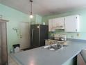 Functional kitchen featuring white cabinetry, stainless steel refrigerator, and tiled floor at 5224 Florida Holly Dr, Orlando, FL 32811