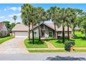 Charming home featuring palm trees, a brick driveway and walkway, and a well-maintained lawn at 526 Sabal Trail Cir, Longwood, FL 32779
