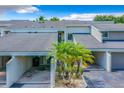 Inviting townhouse with a covered parking space and well-maintained landscaping featuring small palm trees at 5395 Vineland Rd # S, Orlando, FL 32811