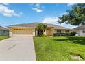 Charming single-story home features a lush front yard with tropical palm trees and an attached two-car garage at 6005 Coal Ct, St Cloud, FL 34772