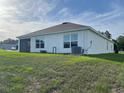 View of home's back exterior, featuring a screened in lanai and a spacious yard at 7172 Sw 135Th Pl, Ocala, FL 34473