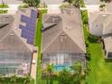 Aerial view of a home with solar panels, a screened pool, and a well-maintained backyard at 7214 Tattant Blvd, Windermere, FL 34786