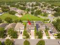 Aerial view of a two-story home with solar panels and a brick driveway in a residential neighborhood at 7214 Tattant Blvd, Windermere, FL 34786