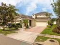 Charming home features a well-manicured lawn, brick driveway, and inviting facade at 7214 Tattant Blvd, Windermere, FL 34786