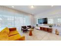 Bright living room featuring stylish furniture, a unique wall mirror, and large windows at 8900 Sydney Ave, Kissimmee, FL 34747