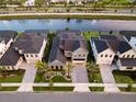 Aerial view of a gray two-story home with backyard pool and canal views at 9352 Santorini Dr, Orlando, FL 32827