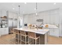 Bright, modern kitchen with marble countertops, a large island, and pendant lighting at 9352 Santorini Dr, Orlando, FL 32827