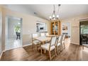 Bright dining room with wood floors, contemporary chandelier, and seating for six at 1010 Leinhart Ct, Oviedo, FL 32765