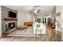 Inviting living room featuring a stone fireplace, wood floors, and a comfortable white sofa at 1010 Leinhart Ct, Oviedo, FL 32765