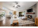 Spacious living room with stone fireplace, wood floors, and sliding glass doors to a lanai at 1010 Leinhart Ct, Oviedo, FL 32765