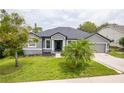 Beautifully landscaped home features tidy landscaping, large windows, and a well-manicured lawn at 1780 Nature Cove Ln, Clermont, FL 34711