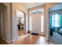 Warm and inviting foyer with tile flooring, chandelier, and a welcome sign above the doorway at 1780 Nature Cove Ln, Clermont, FL 34711